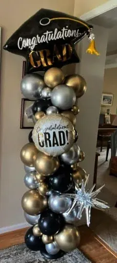 Graduation balloon column in black, gold, and silver with 'Congratulations Grad' foil and silver burst star