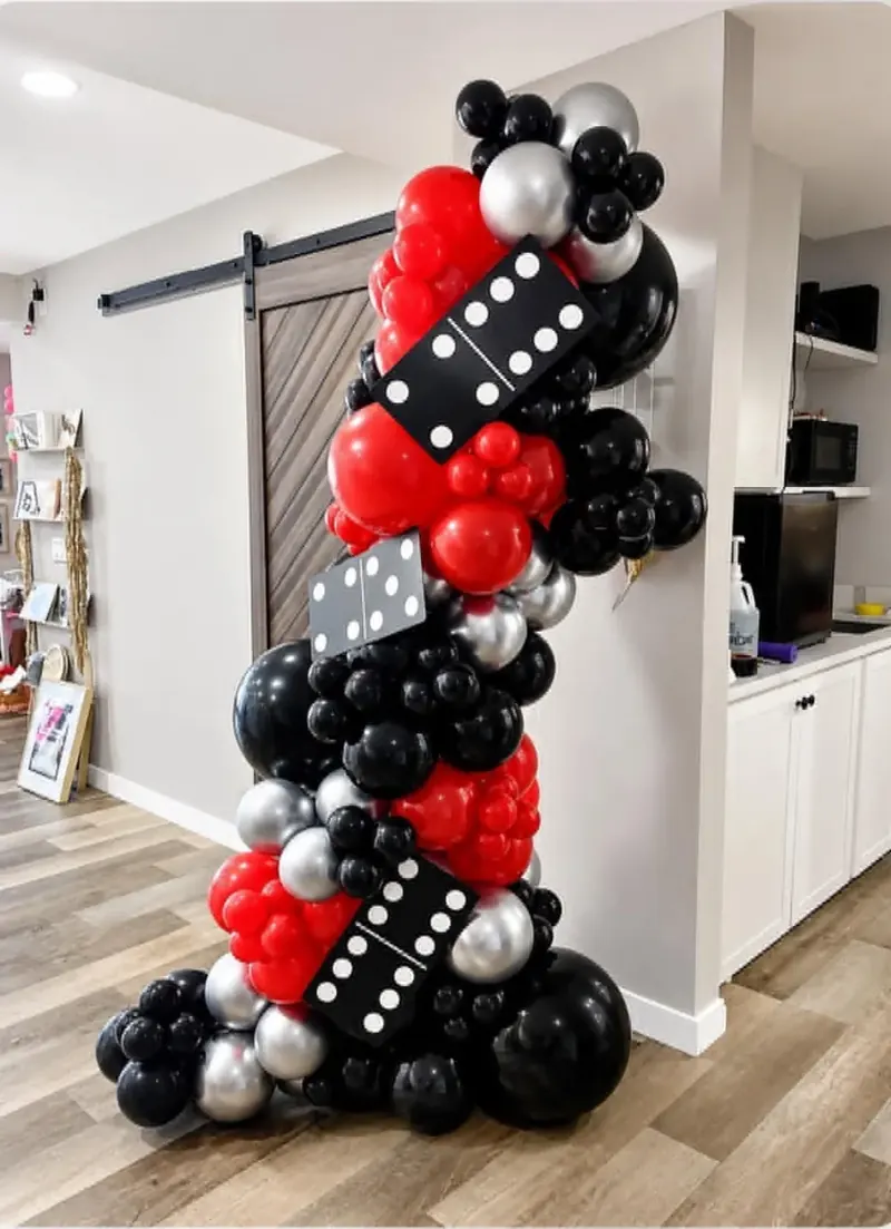 Free-standing balloon column on a stand in red, black, and silver with giant 5-2 and 5-3 domino props for a casino-theme event