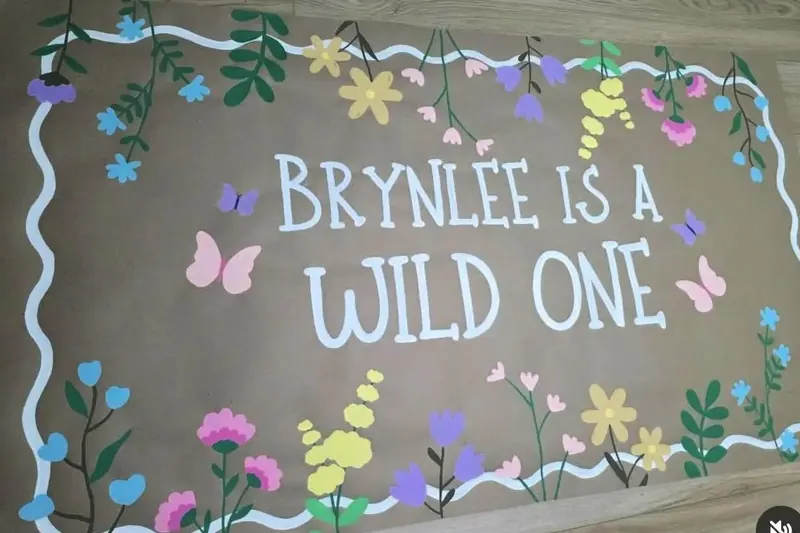 Hand-painted kraft banner: Brynlee is a Wild One with wildflowers and butterflies