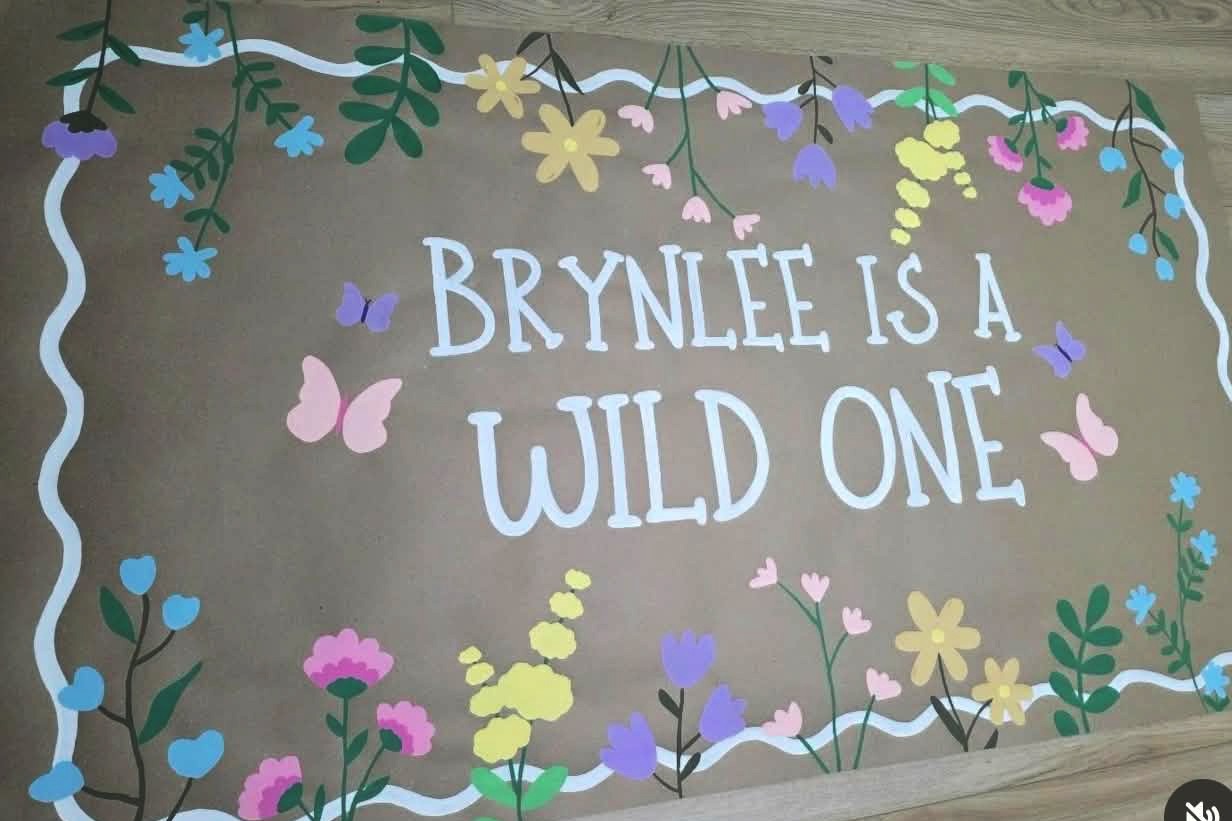 Hand-painted kraft banner: Brynlee is a Wild One with wildflowers and butterflies