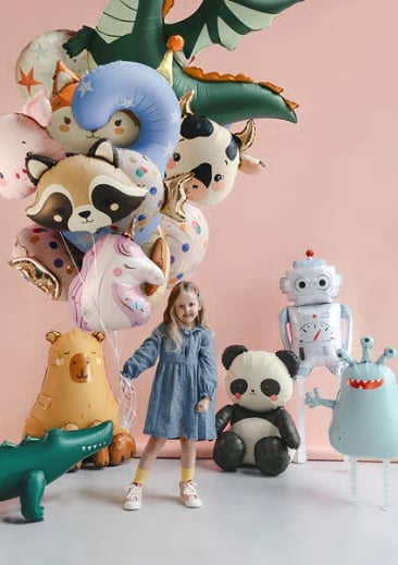 Character mylar balloon bouquet featuring dragon, raccoon, cow, unicorn, panda, robot, monster, and crocodile shapes around a young child
