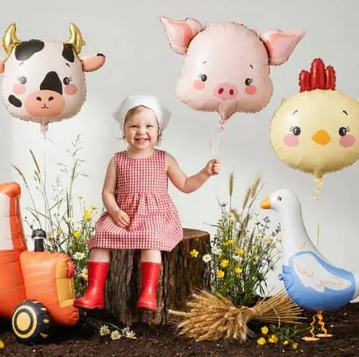 Farm animal mylar balloons — cow, pig, chick, and goose — with a tractor balloon and toddler in a red gingham dress