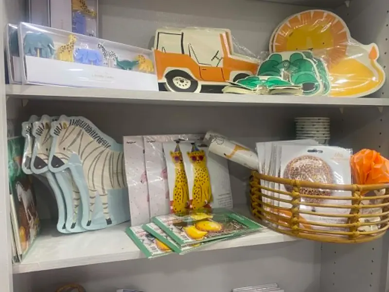 Safari-themed party supplies: jungle animal candles, jeep and lion plates, zebra plates, leopard birthday packs